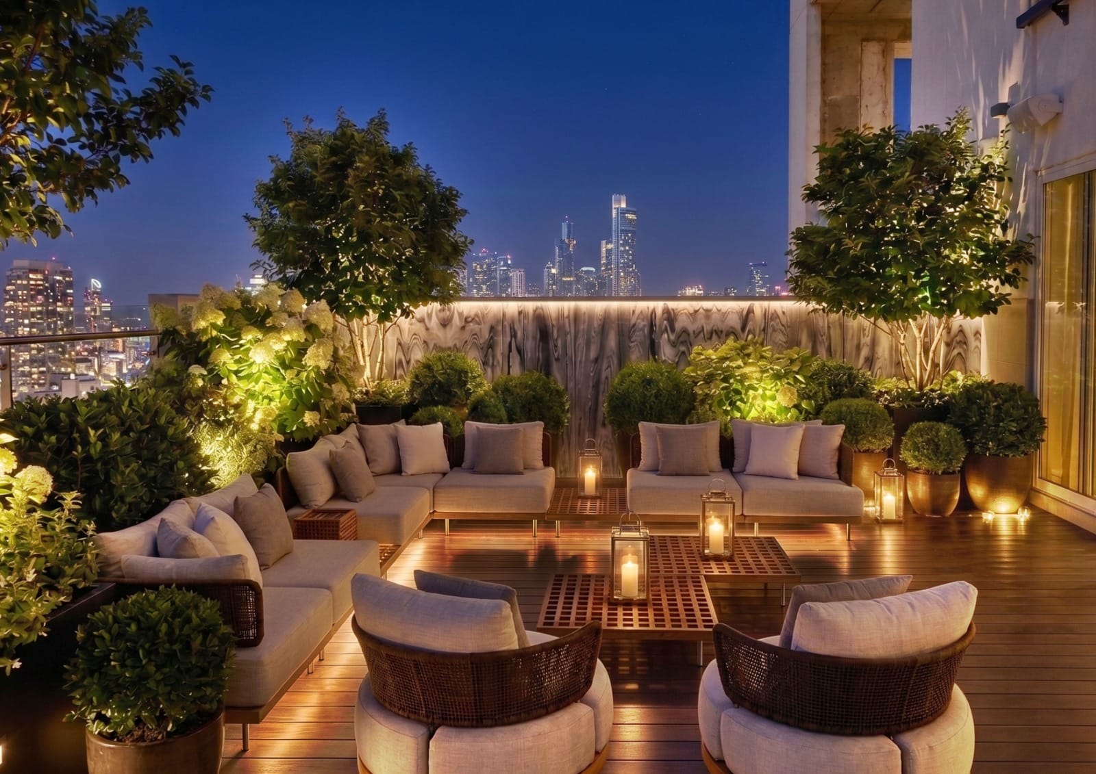 Rooftop lounge with candlelight, greenery, and a skyline view